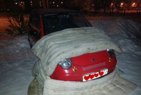 Как девушка заботится о своей машине в мороз.