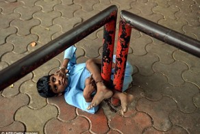 Индийская бабушка привязывает своего внука за ноги к остановке