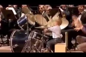 3-летний парнишка играет на барабанах с оркестром