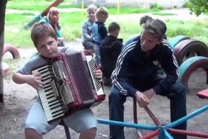 Мальчик играет на аккордеоне. Луганск. 6 июля 2014 года