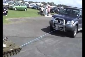 Игрушечный танк тянет на буксире джип