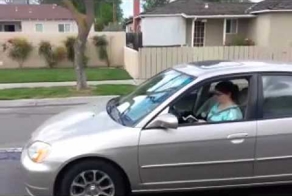 Девушка за рулем с книгой в руках