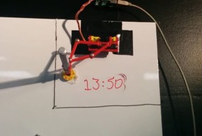 Робот-часовщик рисует время маркером на доске