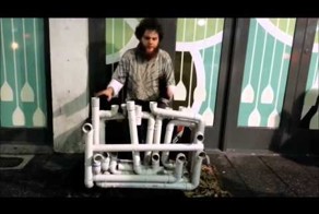 Талантливый уличный музыкант играет на водопроводных трубах