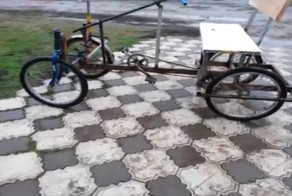 13-летний мальчик показывает свой самодельный четырехколесный велосипед