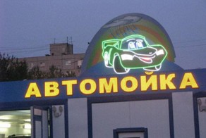 Красивая девушка моет автомобиль