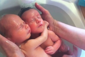 Новорожденные близнецы наслаждаются первым купанием