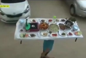 Корейский официант носит на голове обеденный стол, заставленный блюдами