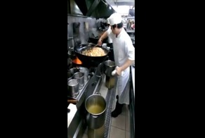 Китайский шеф-повар жарит большую порцию мяса с овощами на воке