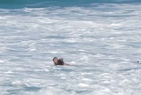 Серфер спасает соперника, сбитого волной