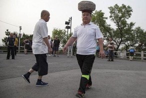 Ради похудения китаец гулял с 40-килограммовым камнем на голове