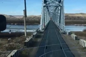 Недовольный водитель едет по железнодорожному мосту