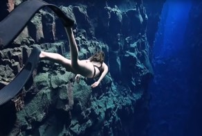 Плавание в кристально чистой воде озера в Исландии