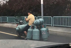 Китаец загрузил 7 газовых баллонов на свой скутер