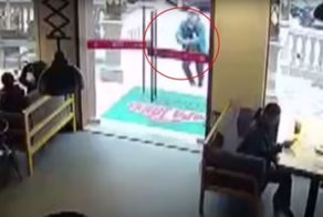 В Китае курьер случайно разбил стеклянную дверь ресторана и остался стоять с металлической ручкой