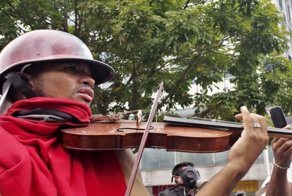 Протестующий играет на скрипке на митинге в Венесуэле