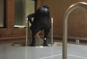 Мужчина пытается слить воду из гидрокостюма
