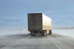 Сильный ветер заставляет прицеп фуры скользить по ледяной дороге