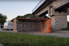 Авария дня. КамАз зацепился кузовом за мост и перевернулся