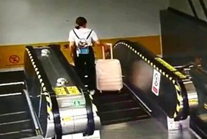 Девушка спускалась на эскалаторе и в неё прилетел чемодан