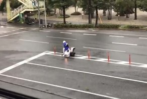 Доставщик пиццы сражается с ветром, вызванным тайфуном Джеби