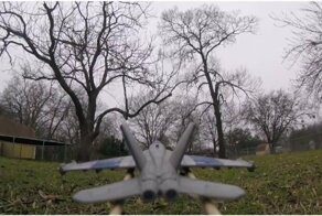 Трюки на игрушечном истребителе, закреплённом на дроне