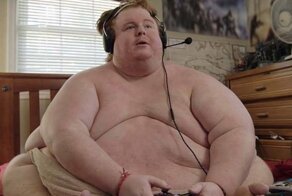 Парень, страдающий от ожирения, целыми днями ест и играет в видеоигры