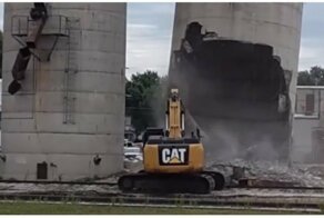  Водитель случайно завалил силосную башню на свой экскаватор во время сноса 