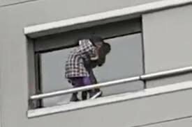 Домработница вылезла за пределы квартиры многоэтажного дома, чтобы помыть окна