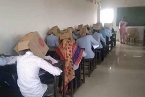 В индийской школе, во избежании списывания, детей заставили сидеть за партами с картонными коробками на головах
