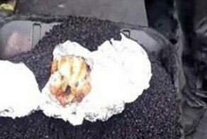 Дорожный рабочий приготовил себе обед в горячем асфальте