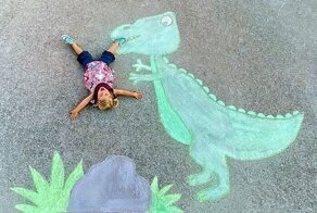 Мама "вписывает" свою дочку в картины, нарисованные мелом на асфальте