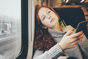 Женщина скрытно фотографирует своих попутчиков на смартфон