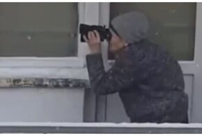 Бабушка с биноклем наблюдает за происходящим вокруг со своего балкона