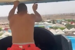 Работник аквапарка устраивает для посетителей аквапарка необычное шоу