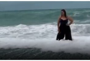 Попытка женщины сделать красивую фотографию на фоне моря