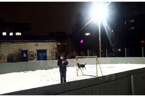 Мужчина выгуливает собаку в хоккейной коробке