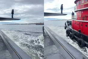 Мужчина шагает с подводной лодки на другой корабль в открытом море