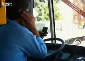 Итальянский водитель автобуса с 2-мя телефонами за рулем