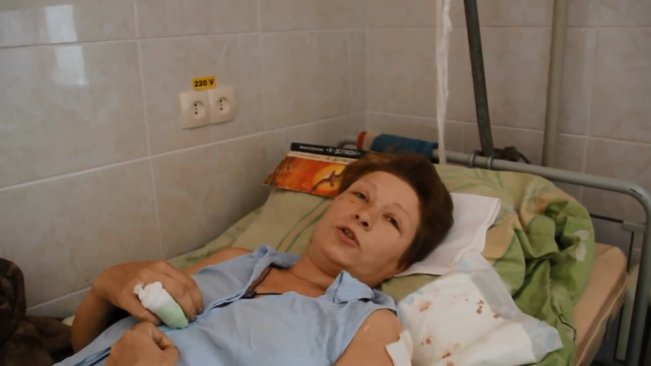 Журналист берет интервью у раненой жительницы Луганска