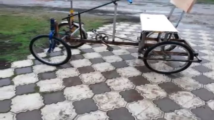 13-летний мальчик показывает свой самодельный четырехколесный велосипед