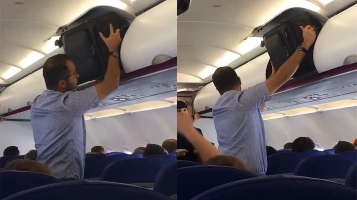 Пассажир самолёта пытается запихнуть свой чемодан