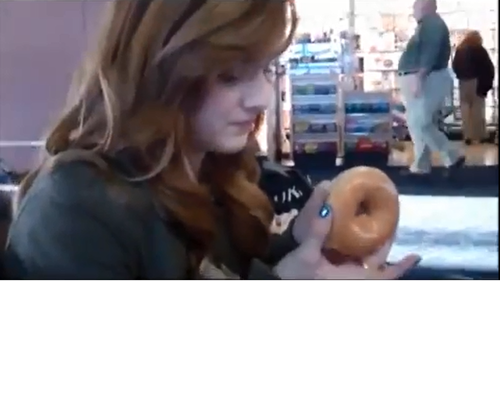 Девушка ест пончик, чтобы не испачкаться кремом 