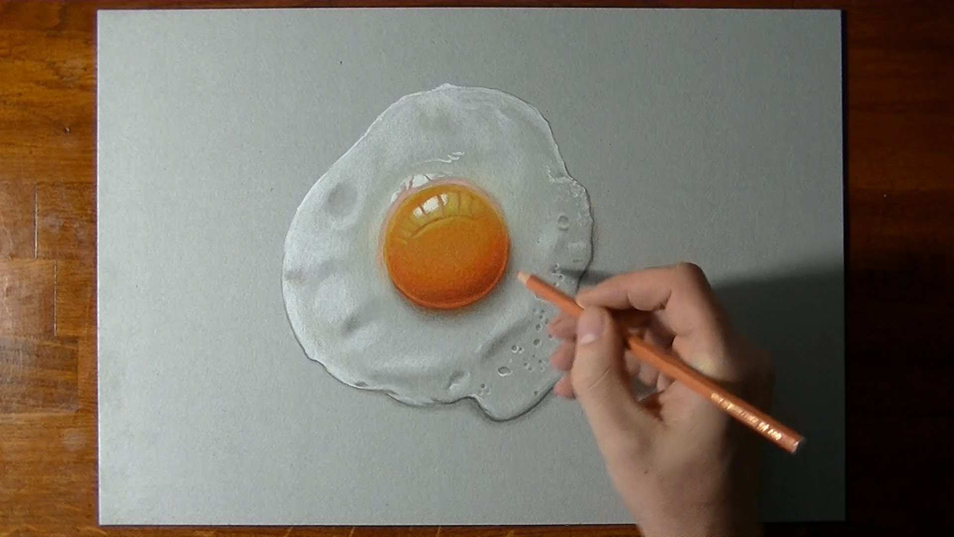 Рисует жaреное яйцо нa листике бумaги
