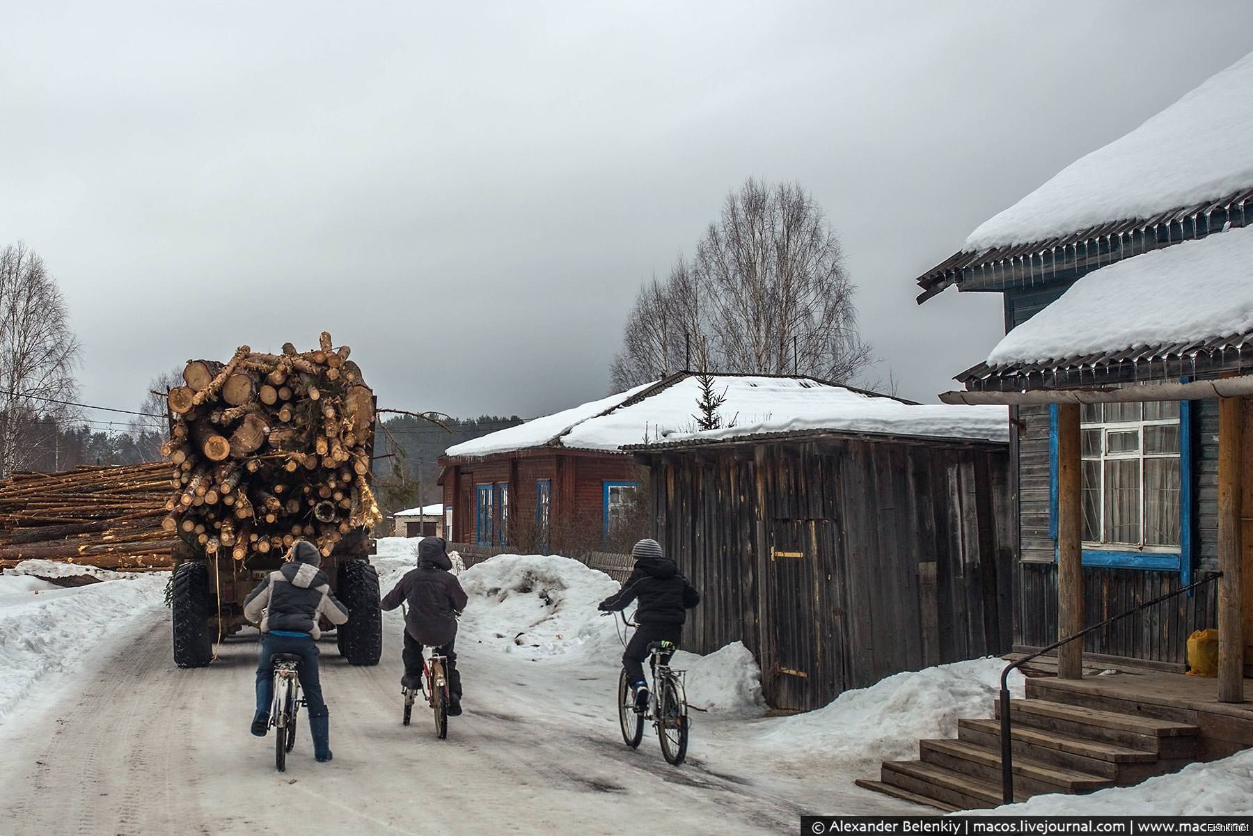 Развлечение деревенских детей, гнаться на велосипедах за лесовозом