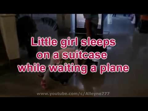 Маленькая девочка спит на чемодане в аэропорте