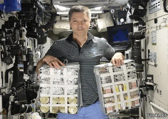 Космонавт Олег Кононенко с формами хранения продуктов в российском сегменте МКС