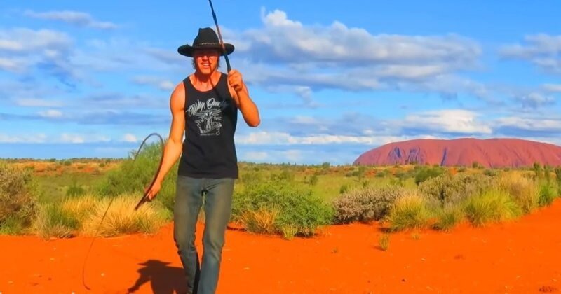 Австралийский парень щелкает кнутами под музыку