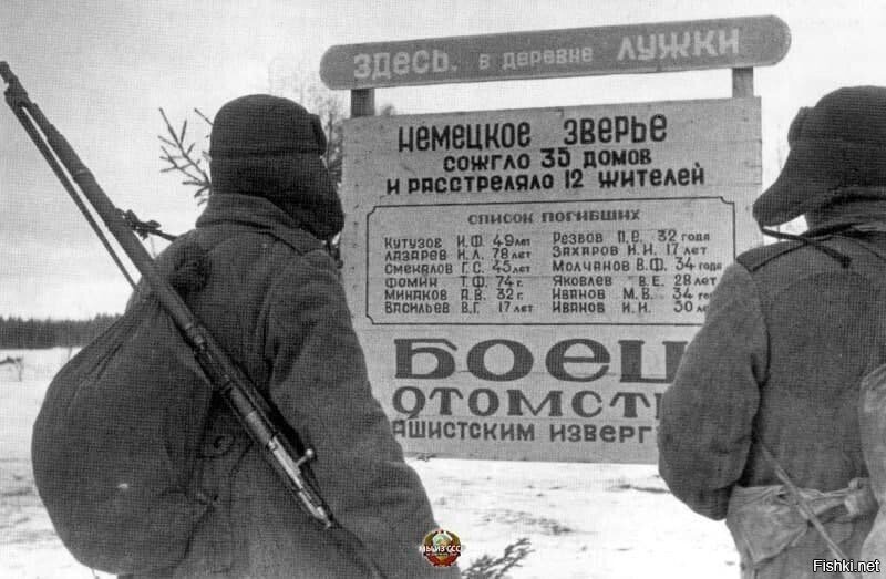 Советские coлдаты перед плакатом, сообщающим о зверствах немцев