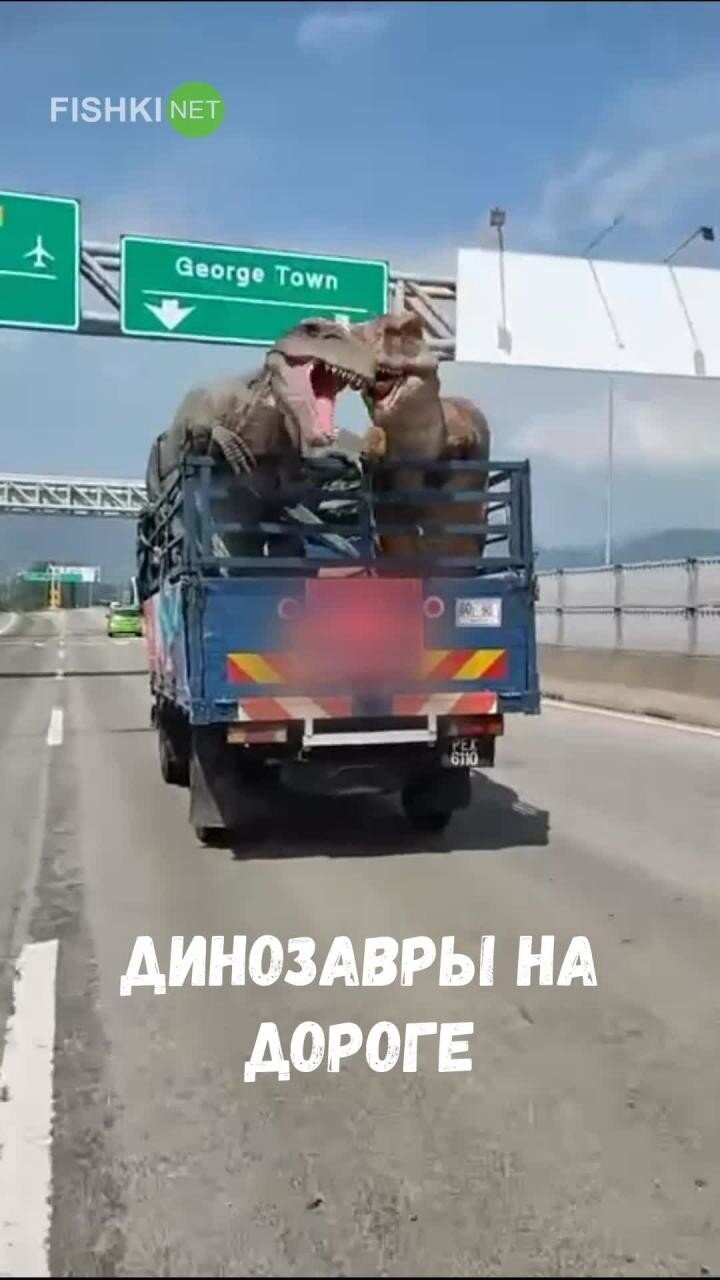 Два динозавра едут на грузовике по шоссе